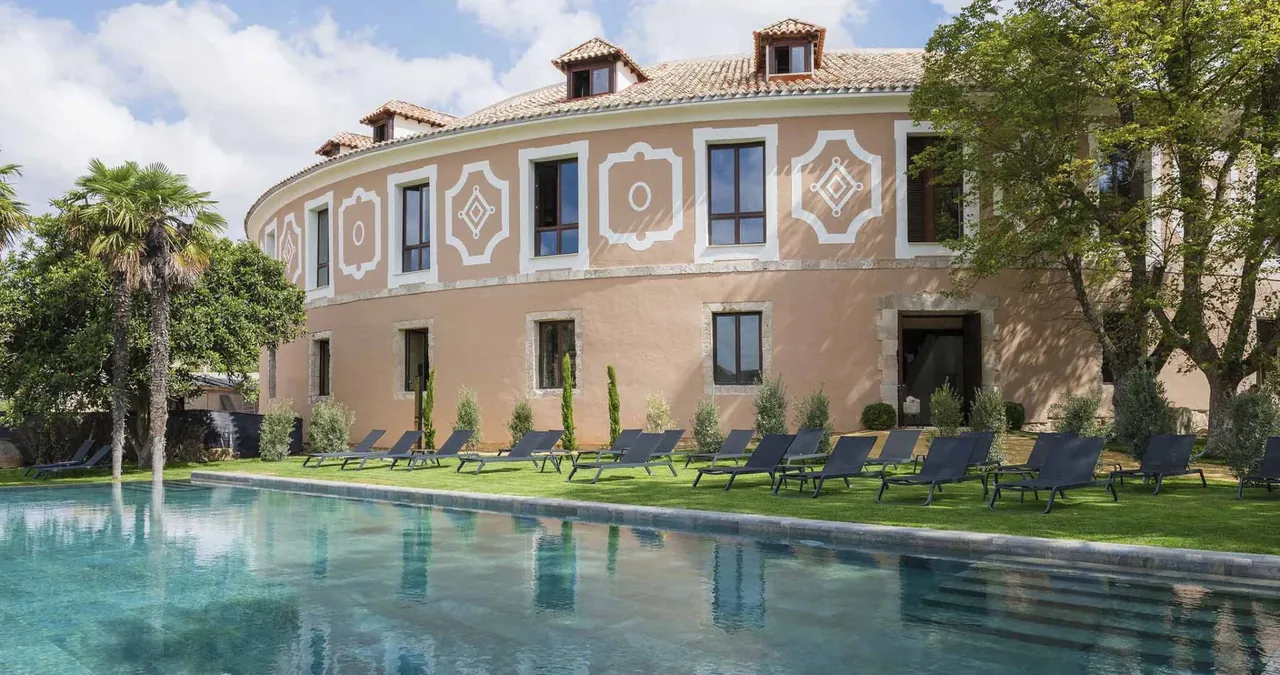 La fachada circular de la Real Fábrica de Paños, con la piscina exterior y el jardín